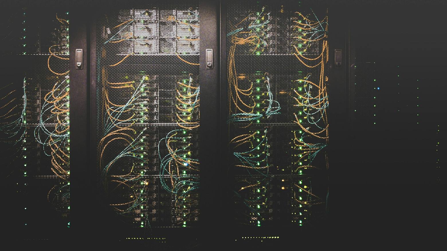 Rows of server racks with bundled network cables in a data hall