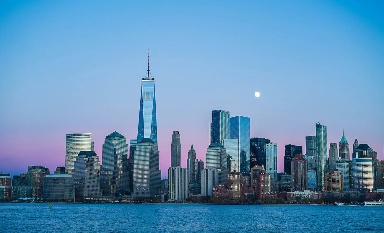 City street at dusk with illuminated office towers